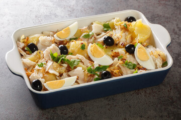 Bacalhau a Gomes de Sa salt Cod, Onions and Potatoes closeup in the baking dish on the table....