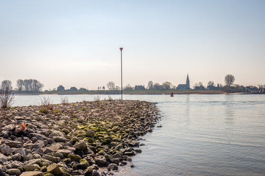 Groyne of basalt blocks in the wide Dutch river Waal. The photo was taken near the village of Vuren, province of Gelderland. On the other side of the river is the village of Zuilichem.