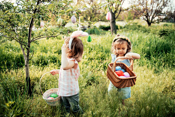 Easter egg hunt. Group Of Children Wearing Bunny Ears Running To Pick Up colorful Egg On Easter Egg...