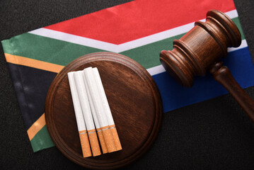 Flag of South Africa, cigarettes and Judge gavel. Sales of cigarettes in Japan. Tobacco law in...