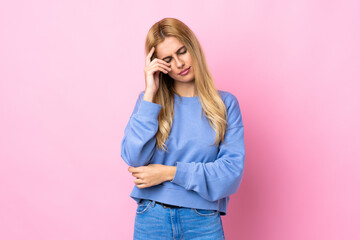 Young Uruguayan blonde woman over isolated pink background with headache