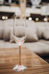 Empty champagne glass on a background of blurred sofa