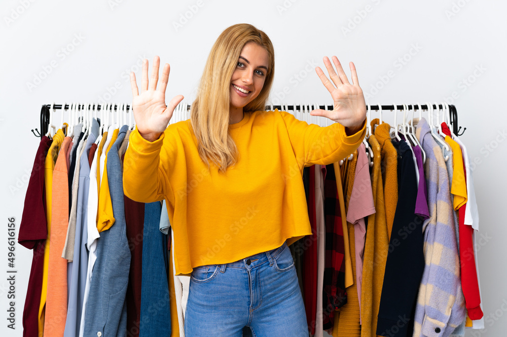 Canvas Prints Young Uruguayan blonde woman in a clothing store counting ten with fingers