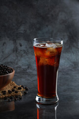 Iced Americano coffee in the glass with coffee beans in background. Diet drink or no sugar concept.