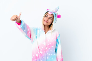 Blonde Uruguayan girl wearing a unicorn pajama isolated on white background giving a thumbs up gesture