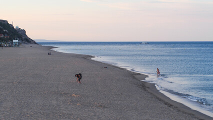 Plage de Port-Leucate, en fin de soirée.  Quelques personnes se baladent le long de la mer