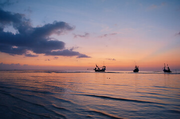 Beautiful tropical sunset. Seascape with purple sky and longtail boats. Samui Island, Thailnd.