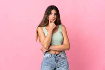 Young caucasian woman isolated on pink background thinking