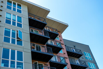 Low angle view of a modern style business building, with lots of windows on a sunny, cloudy day