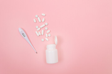 White Pills or Tablets with Electronic Thermometer on Pink Background. Pharmaceutical Industry and Medicinal Products