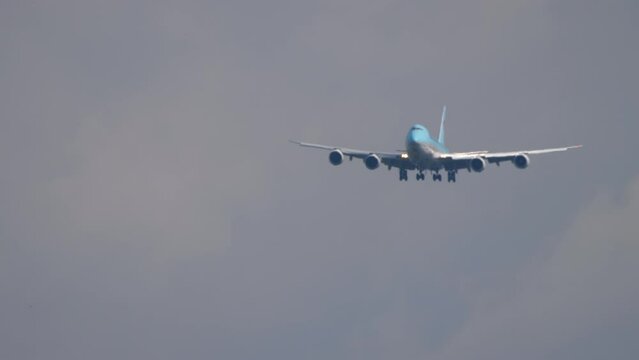 Front view, a huge four-engine jet plane descends to land. Slowly, the airliner is flying and ready to land. Air industry, travel and tourism concept