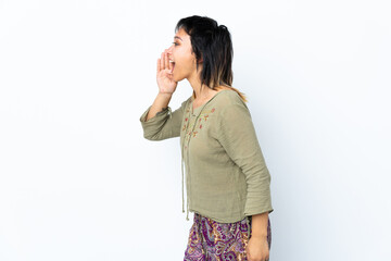 Young Uruguayan girl over isolated white background shouting with mouth wide open to the side