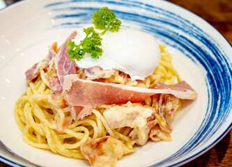 Egg yolk Pasta alla Carbonara. A fork spindles from a bowl of linguine carbonara. Italian Food