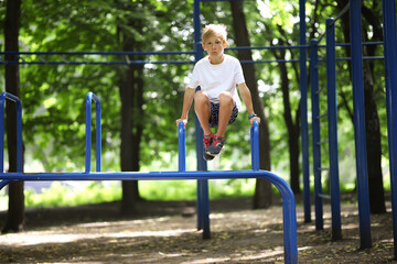 Fototapeta na wymiar boy in the park on horizontal bars