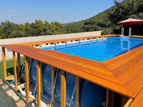Swimming pool in the garden with wooden pool deck in construction	