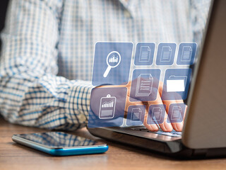 Businessman working at a laptop and digital documents on a virtual screen