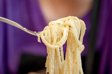 Egg yolk Pasta alla Carbonara. A fork spindles from a bowl of linguine carbonara. Italian Food