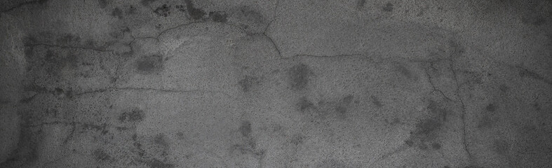 Old gray cement wall with cracks on the surface.	