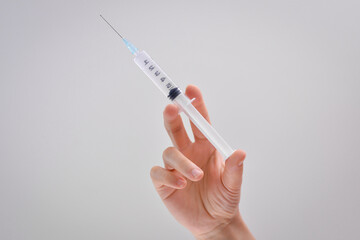 Syringe in a hand of a woman. Vaccine disease preparing for child, baby, adult, man and woman vaccination shot, medicine and drug concept.