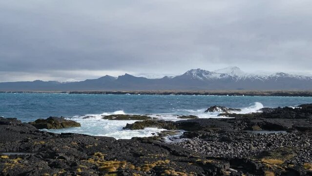 Atlantic ocean coast scene with black volcanic rocks on Ondverdarnes Cape - the Westernmost Point on the Saefellsnes Peninsula in West Iceland Snaefellsnes Peninsula, Snaefellsjokull National Park.