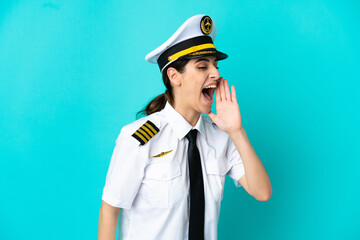 Airplane pilot caucasian woman isolated on blue background shouting with mouth wide open to the side