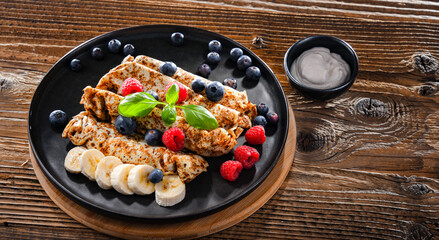 A plate of pancakes with cheese and fruits