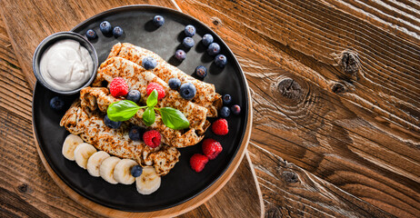 A plate of pancakes with cheese and fruits