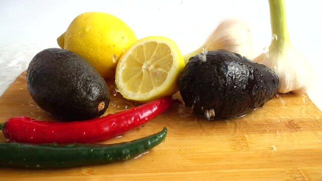 Lemon, avocado, chilli pepper and garlic under water