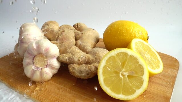 Ginger root, garlic and lemon under water splashes.