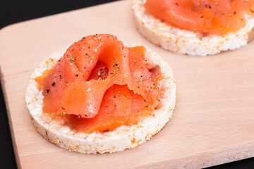 Tasty Rice Cake Sandwiches with Fresh Salmon Slices on Cutting Board - Close-Up. Easy Breakfast and Diet Food. Crispbread with Red Fish. Healthy Dietary Snack