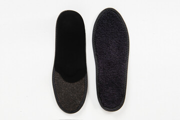 Black Insoles isolated on a white background. Medical orthopedic insoles. Foot care. Insole cutaway layers. Treatment and prevention of flat feet and foot diseases. Inner soles of shoes.