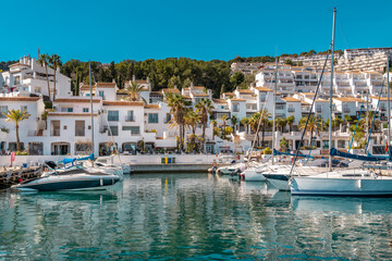 Bay area situated in la provincial de Granada. Beautiful harbour with luxury yachts docked in a small bay. All the dock area surrounded by restaurants - obrazy, fototapety, plakaty