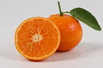 oranges, halved oranges, healthy fruit, mandarin oranges, vitamin C, against white background with refreshing water droplets