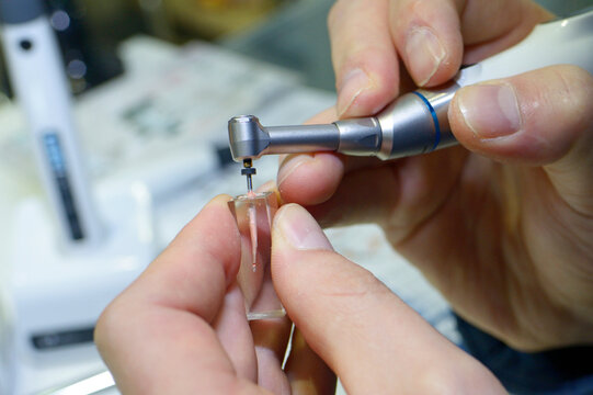 Doctor hands showing how root canal filling injector is working
