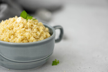 boiled millet porridge with butterl and parsley in a gray plate