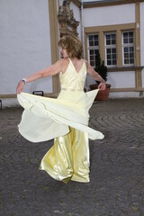 Fototapeta na wymiar woman in an elegant evening dress dances barefoot in the neuhaus palace park, nrw, close to paderborn