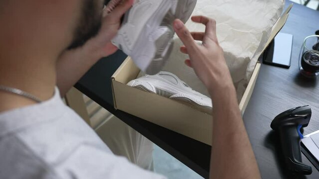 Closeup view of male online store small business owner seller entrepreneur packing package post shipping box preparing delivery parcel on table. Ecommerce dropshipping shipment service concept.