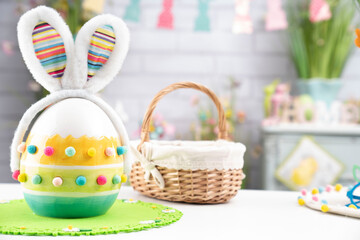 Easter time. Easter decorations on the white background. Easter bunny, easter eggs in basket. Bouquets of spring flowers. 