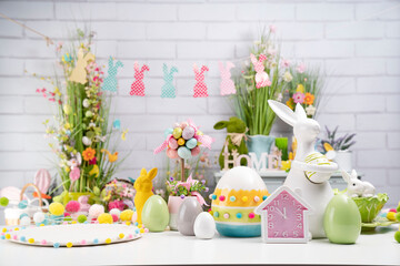 Easter time. Easter decorations on the white background. Easter bunny, easter eggs in basket. Bouquets of spring flowers. 