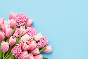 Bouquet of pink tulips and hyacinth on a light blue background. Flat lay, copy space for text
