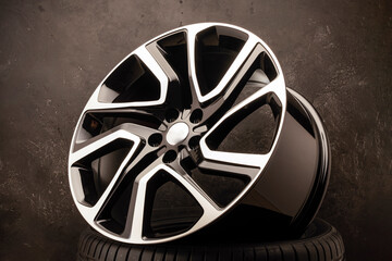 new stylish alloy wheel on the tire dark textured background, beautiful and expensive, 20 -21, 22...