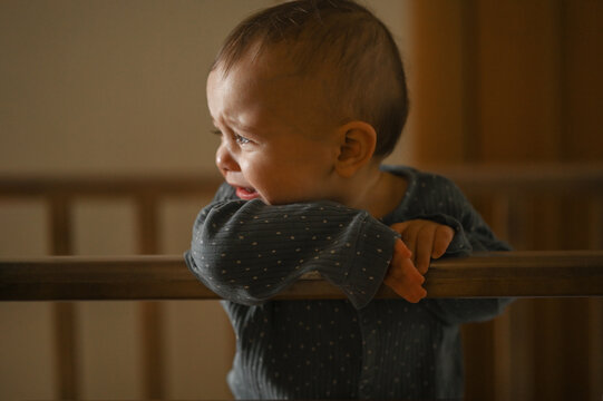 a six-month-old baby is crying in a crib