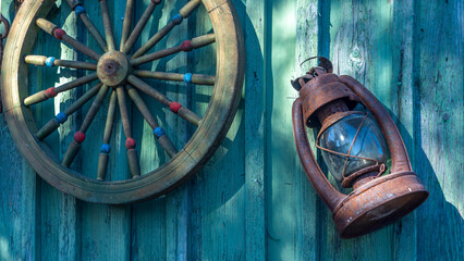 Betty lamp and spinning wheel in the background of the old log-house wall with sign nomber one. Rural retro still life.