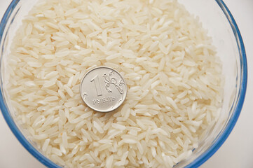 rice grits and 1 ruble in a glass plate. healthy porridge. vegetarian food. rice for rubles.