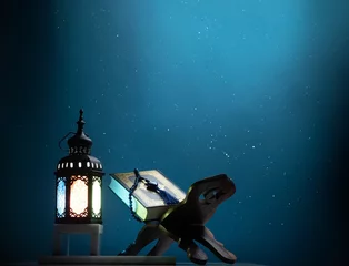 Fotobehang Kuran or Quran , the holy book of all Muslim shined by brighten lantern © missisya
