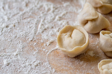 Fototapeta na wymiar Few raw meat dumpling, raw dough and white flour. Uncooked dumpling.