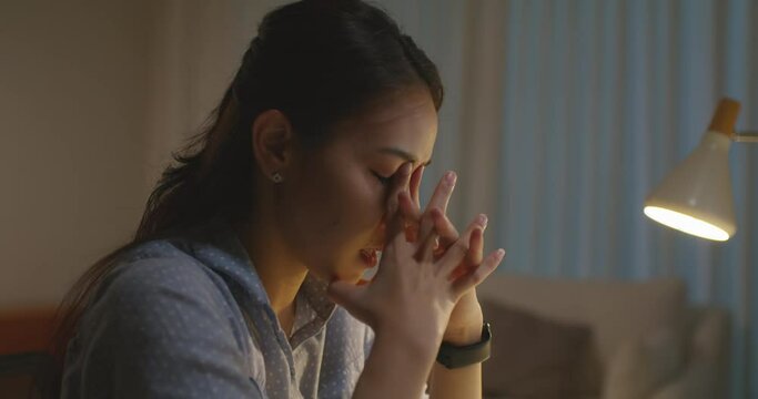 Asia people young woman study hard overnight brownout bored remote learn online read data tired sitting head in hands at home office desk workplace think worry in job tough stress workforce issue.