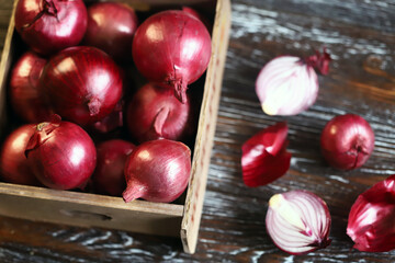 Blue bow in a wooden box. Cut red onion.