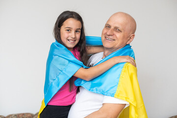Ukrainian Grandfather and granddaughter with laptop and flag of Ukraine