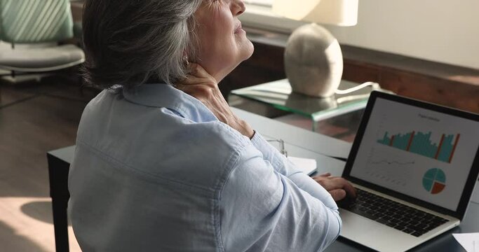 Close up rear view 50s woman suffer from neck ache, massage stiff sore neck or tensed muscles, relieving painful feelings. Incorrect posture, fibromyalgia, chronic disease, sedentary lifestyle concept